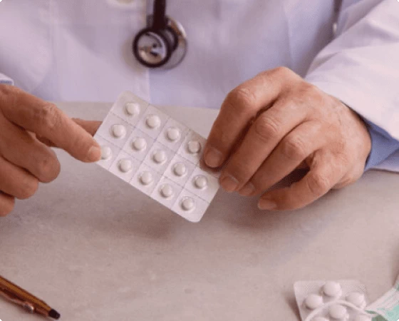 Врач держит упаковку таблеток в руке